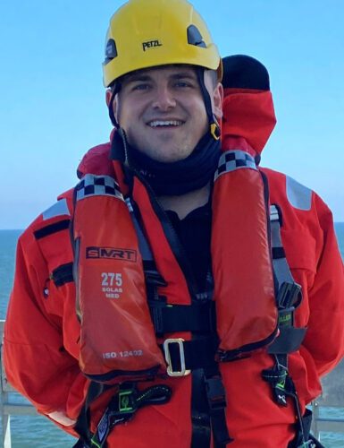 Arran Cruickshank ready to climb, wearing a hard hat and safety gear.