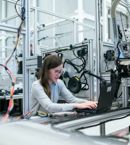 A woman in a electrical environment working on a laptop