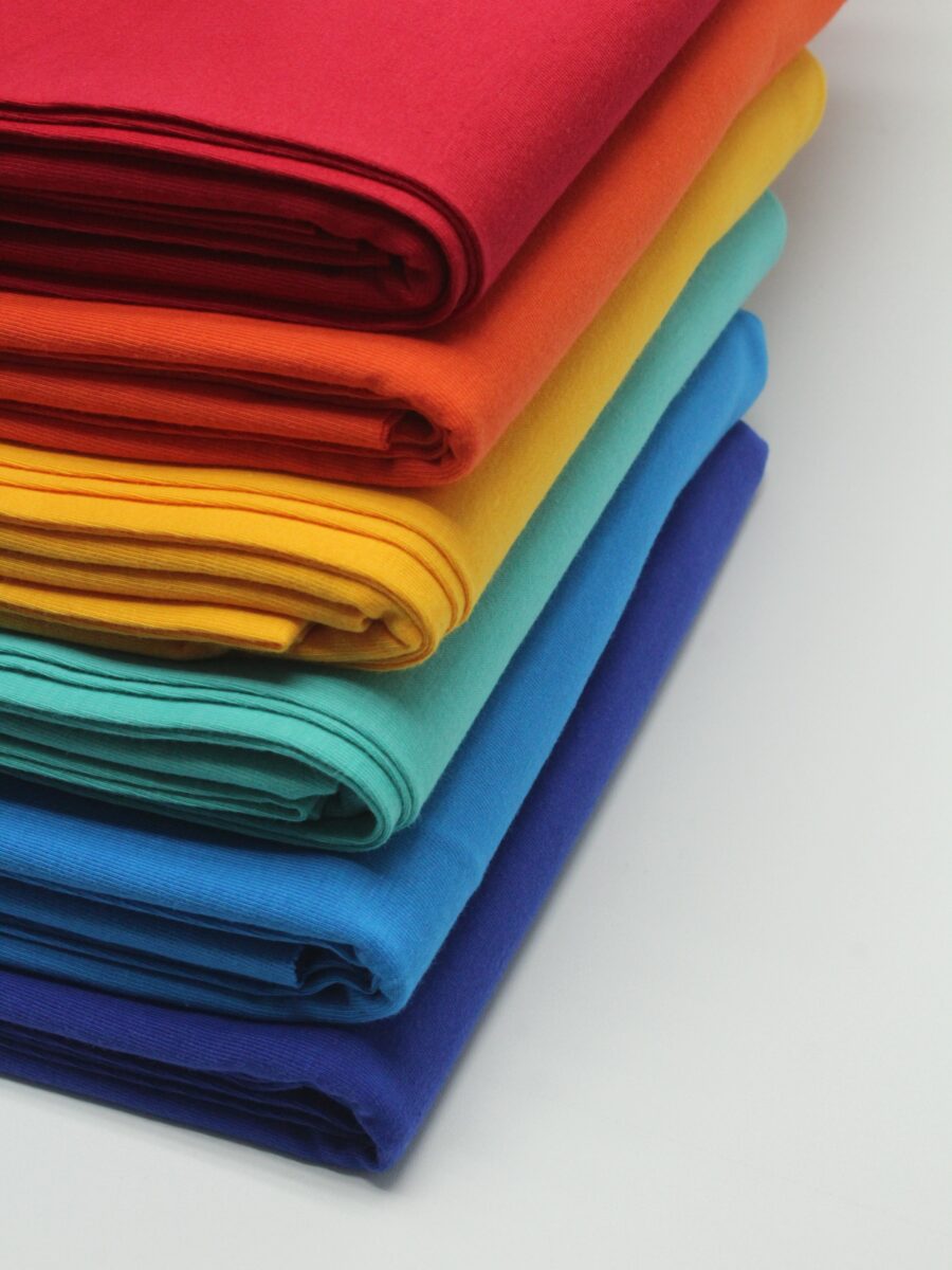 A pile of neatly folded fabrics of different colours.