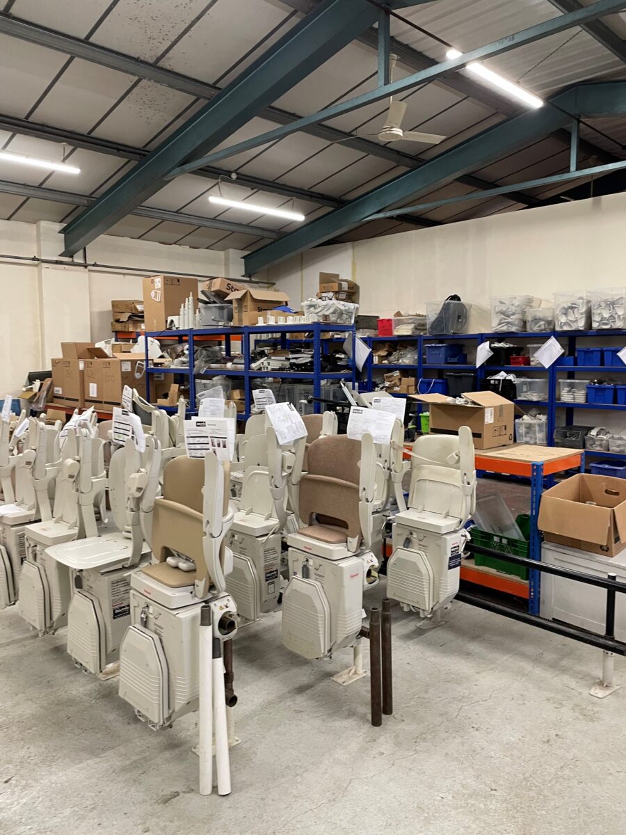 Ben Pike's workplace, a warehouse containing racks of stairlifts, ready for installation.