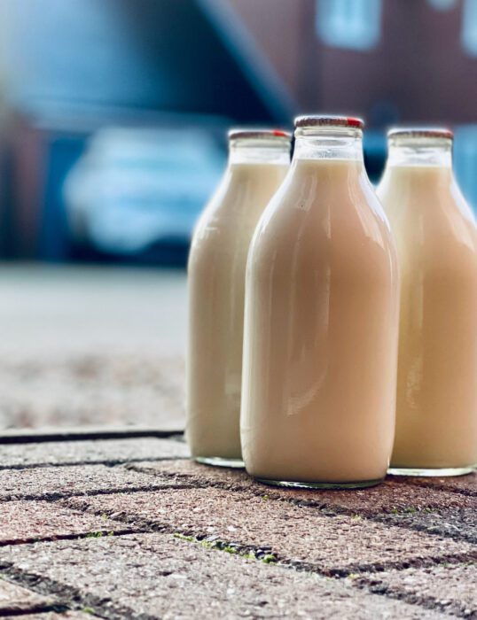 Three milk bottles on the ground.