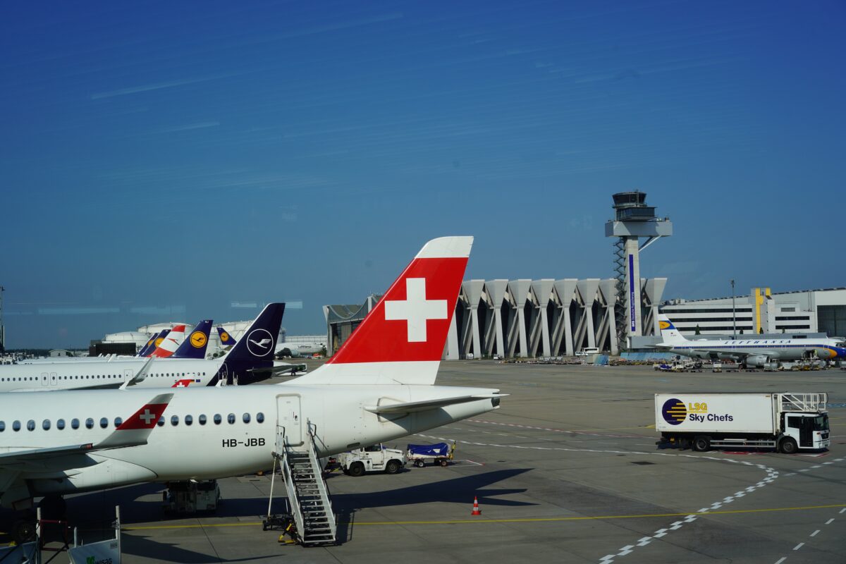 Planes parked on the tarmac at an airport.