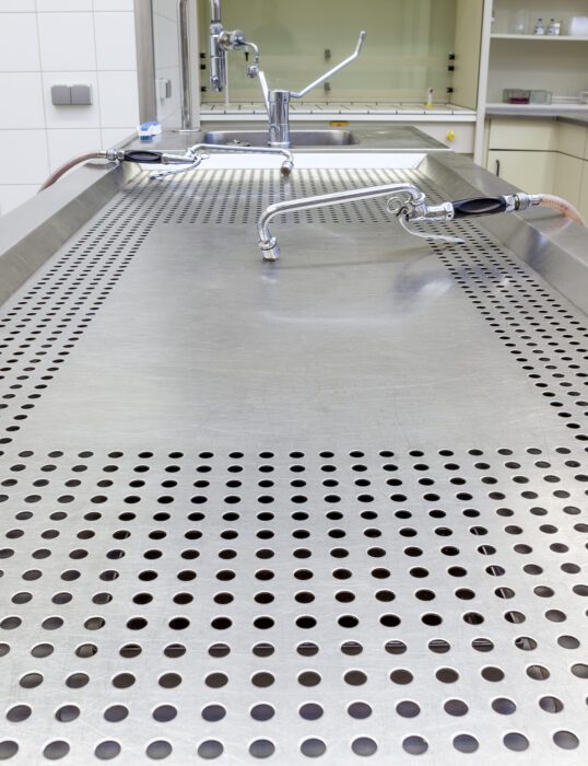 An empty and clean mortuary table.