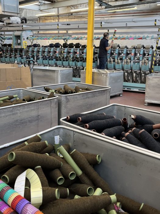 A technician maintaining weaving machines in a textiles factory.