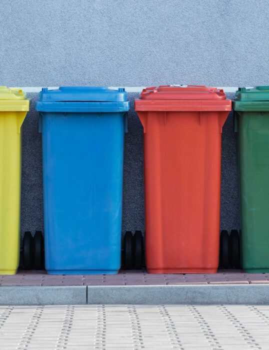 Wheelie bins lined up in front of a house.