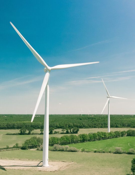 Two wind turbines in a field.