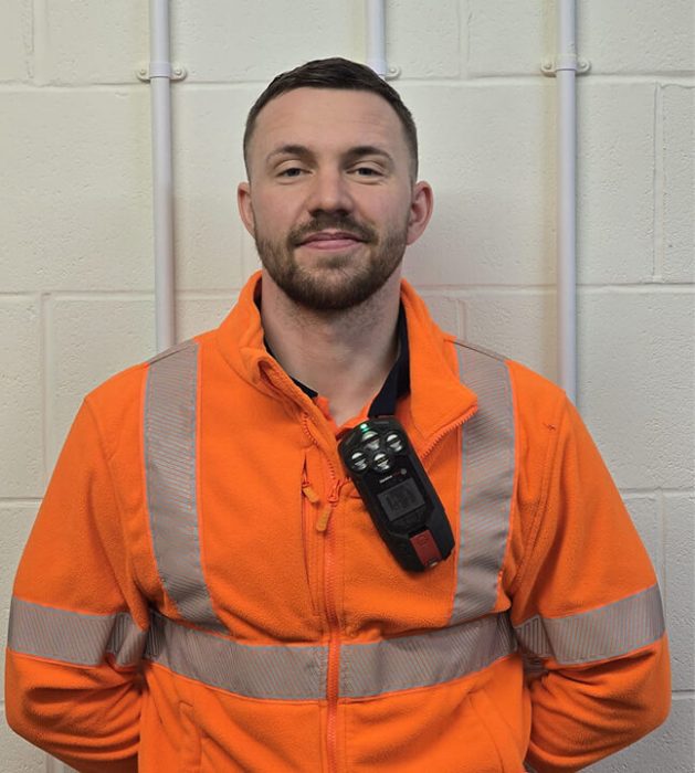 John stood facing forwards in his orange hi vis uniform
