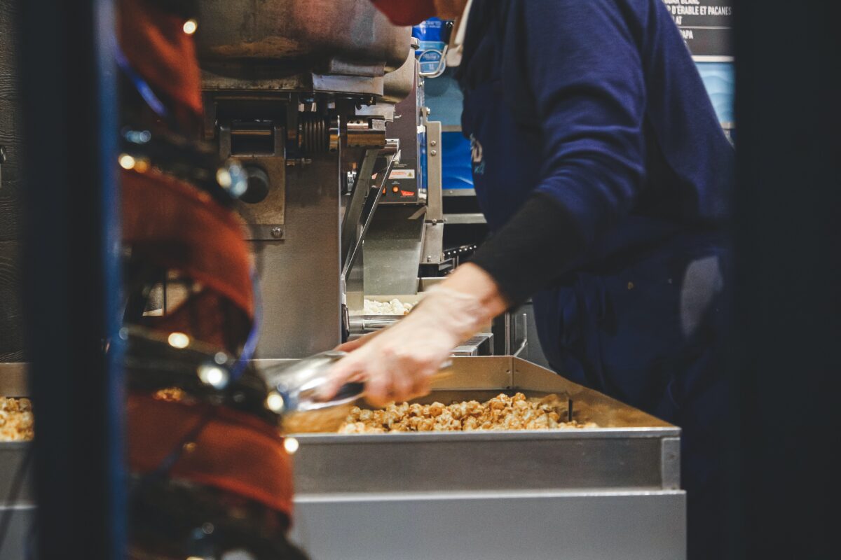 Ruel working in a food factory, surrounded by industrial machinery.