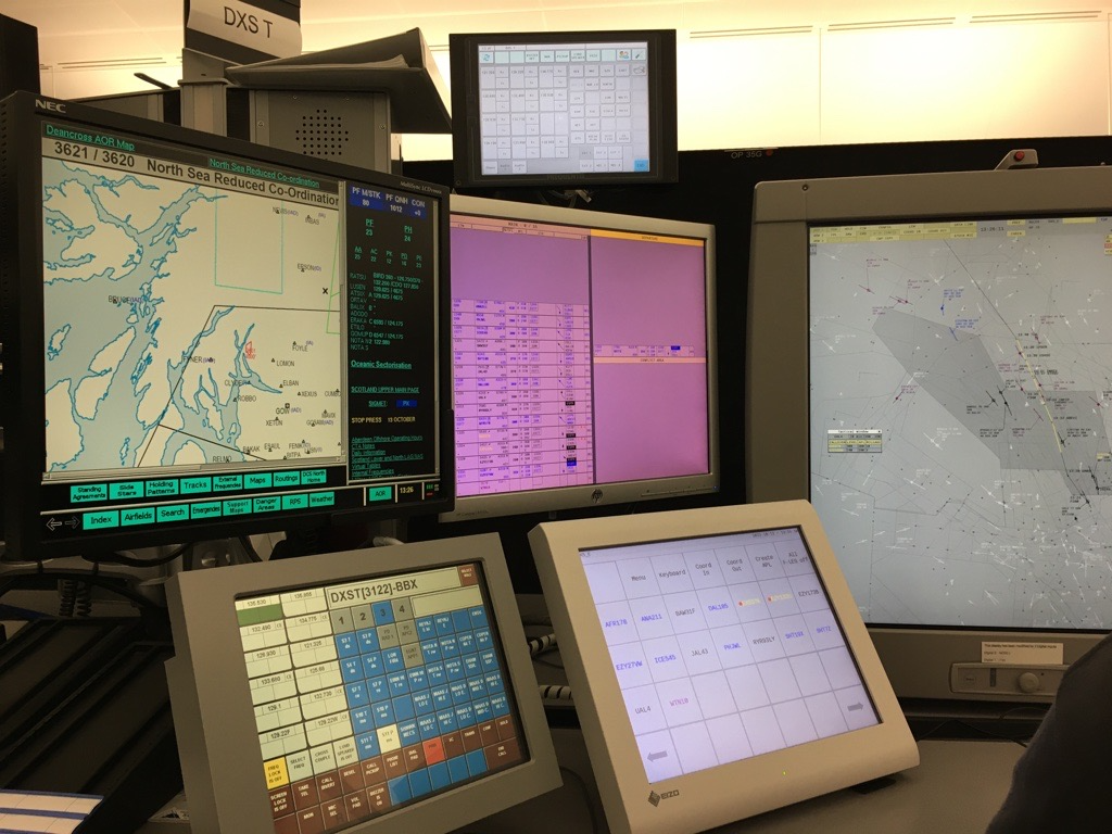 Glen's desk, with six screens showing data including the location of aircraft on a map, and flight times.