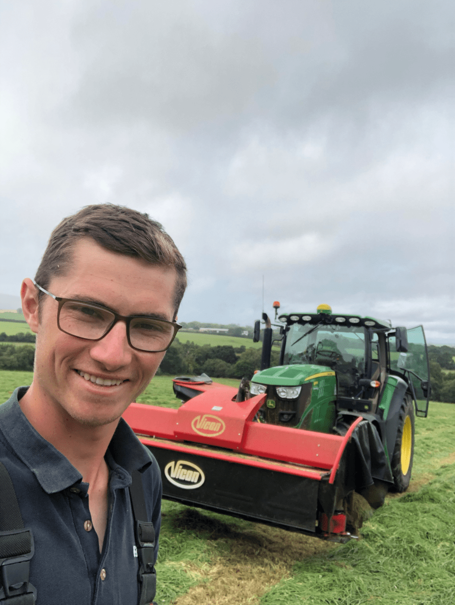 Josh taking a selfie on the farm, next to his tractor.
