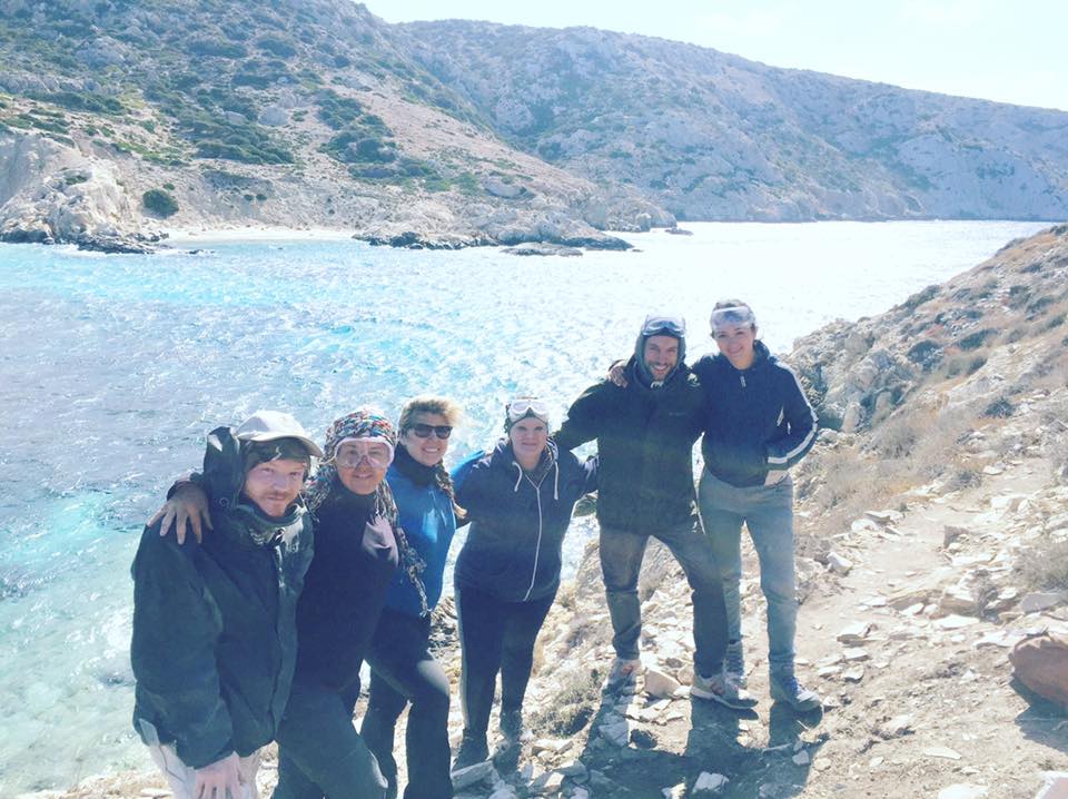 Yvette and colleagues on a field trip, posing next to a lake.