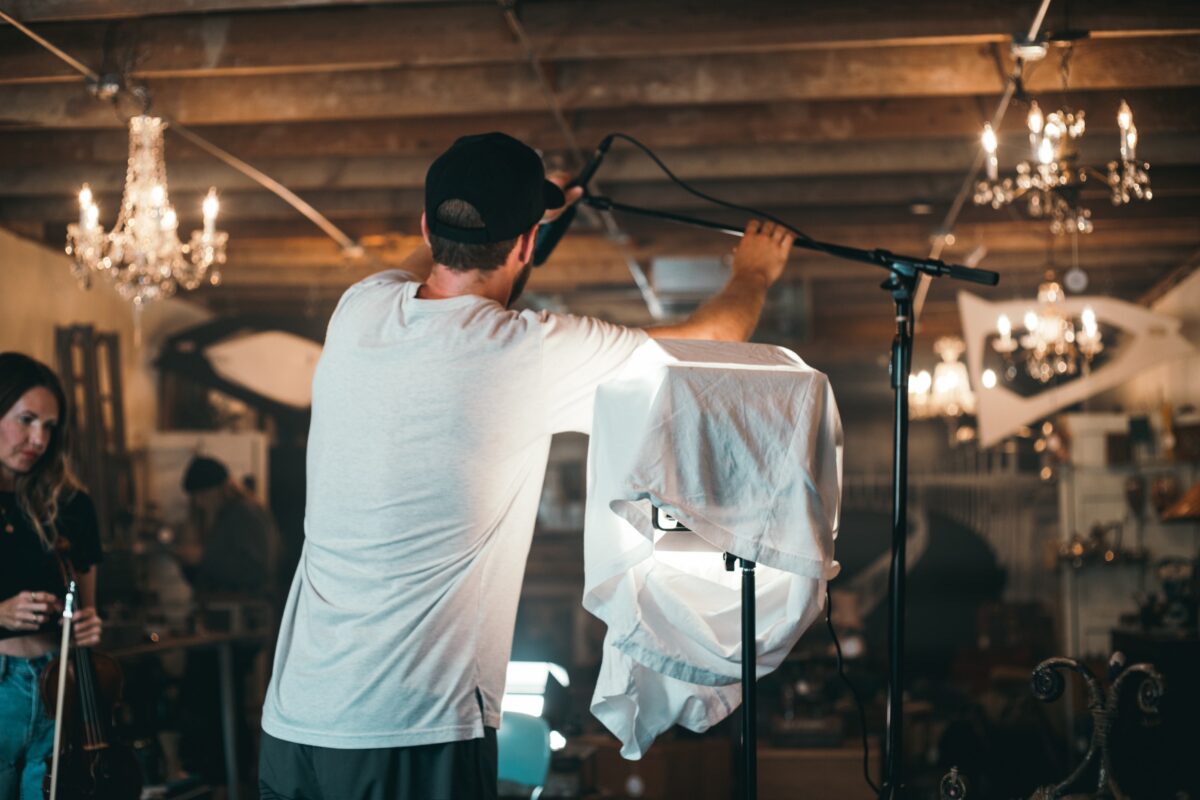 Jordan setting up a microphone on a film set.