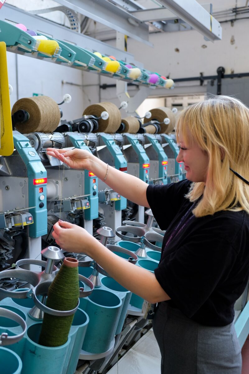 Amy O'Hare supervising an industrial cotton weaving machine.