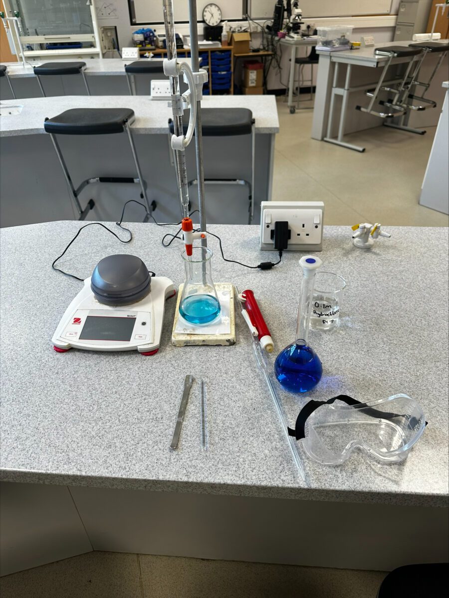 Equipment for a science practical activity set up and ready to go on a desk, in a school lab.