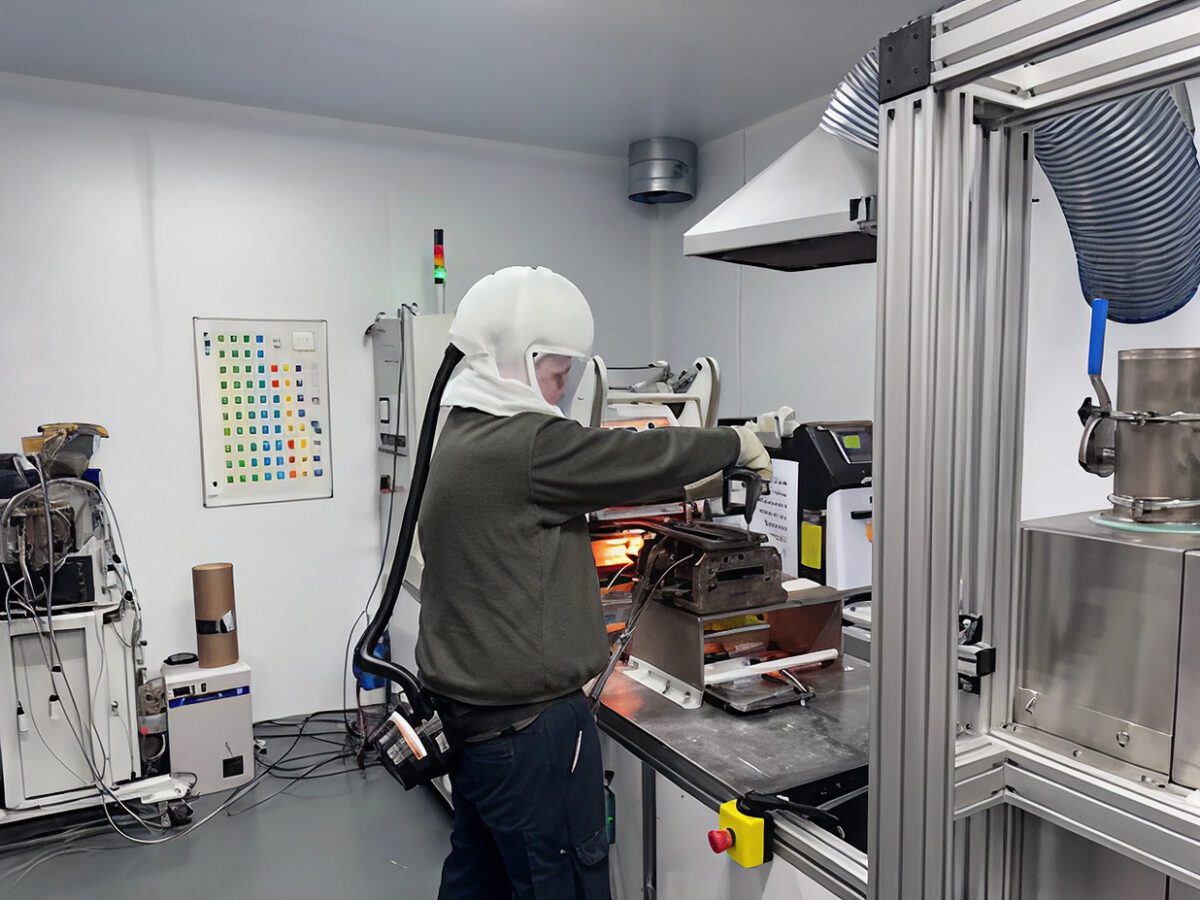 Ben working in a ventilated workshop, wearing a ventilated safety mask, and gloves.