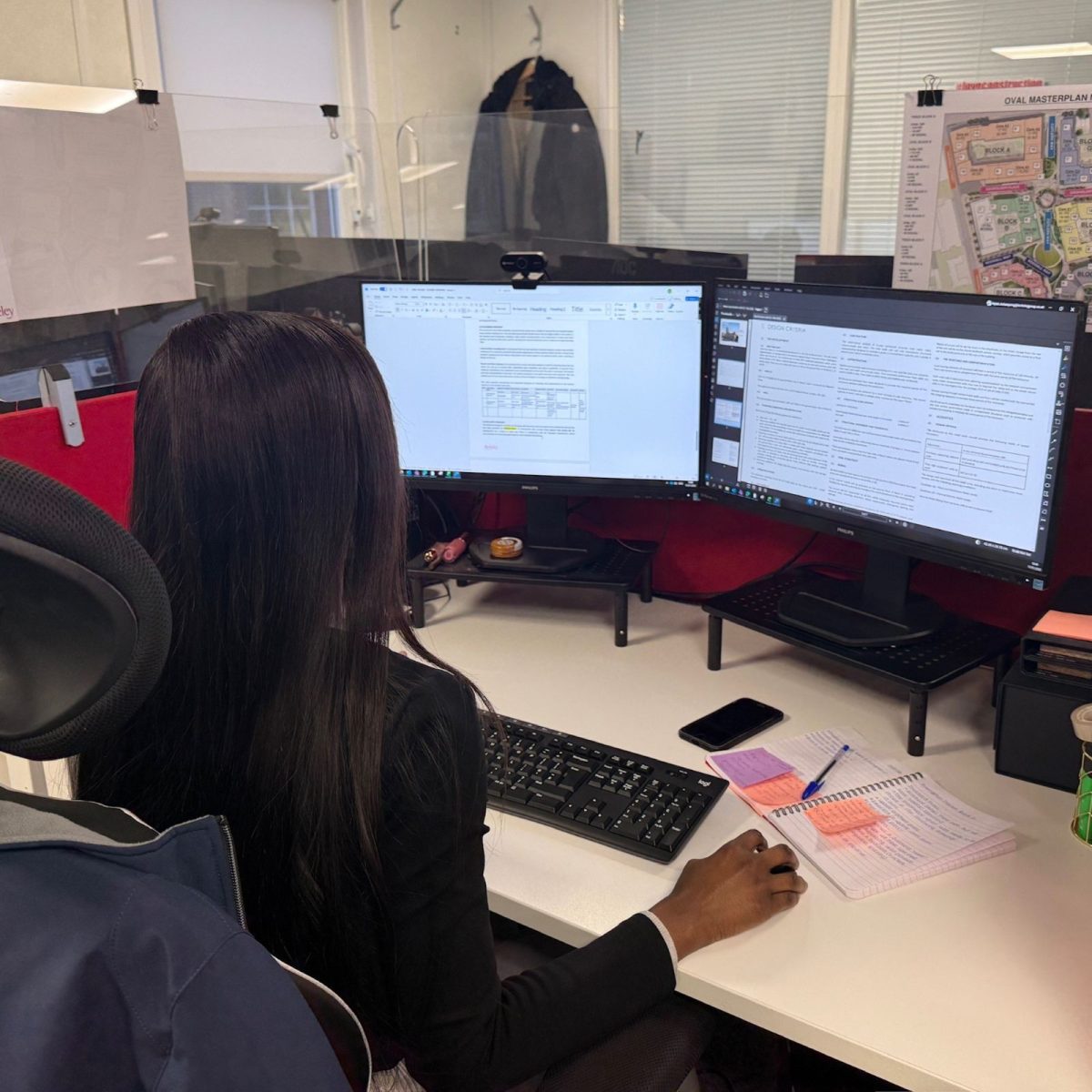 Nylah sat at a desk, working at a computer with two screens.