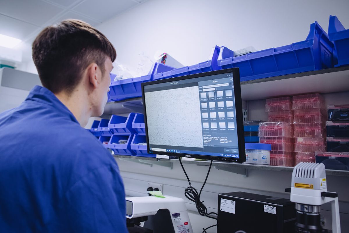 A man using a computer in a laboratory supply room