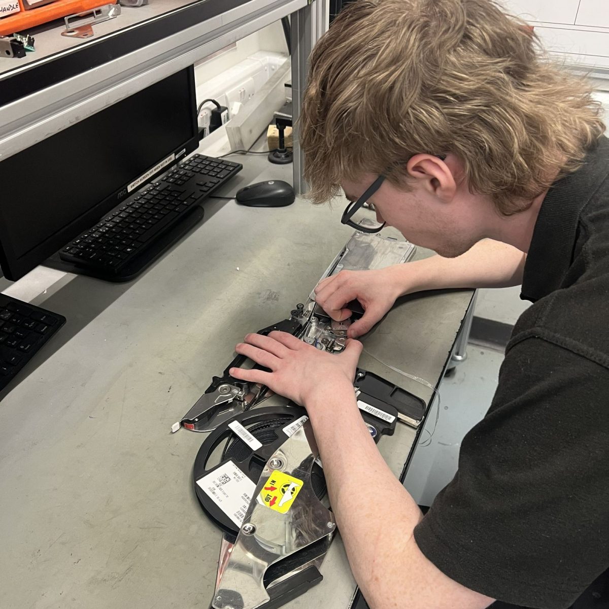 Maintenance and Operations Engineering Technician Troy, putting together a piece of equipment on a worktable.