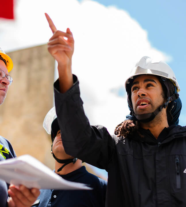 A mean wearing a hard hat on a building site.
