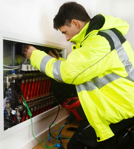 A mean working inside wearing a yellow hi-vis rain coat.